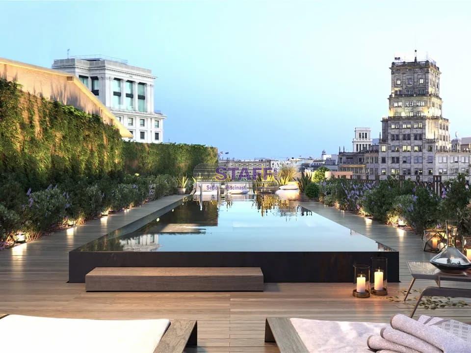 piscine charmante sur un toit avec vue sur la ville au coucher du soleil